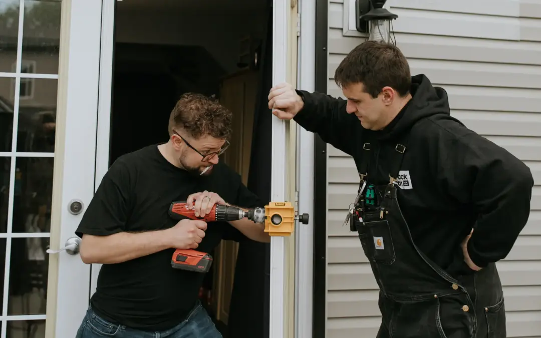 two locksmiths working on replacing a door lock-Black cat lock and key